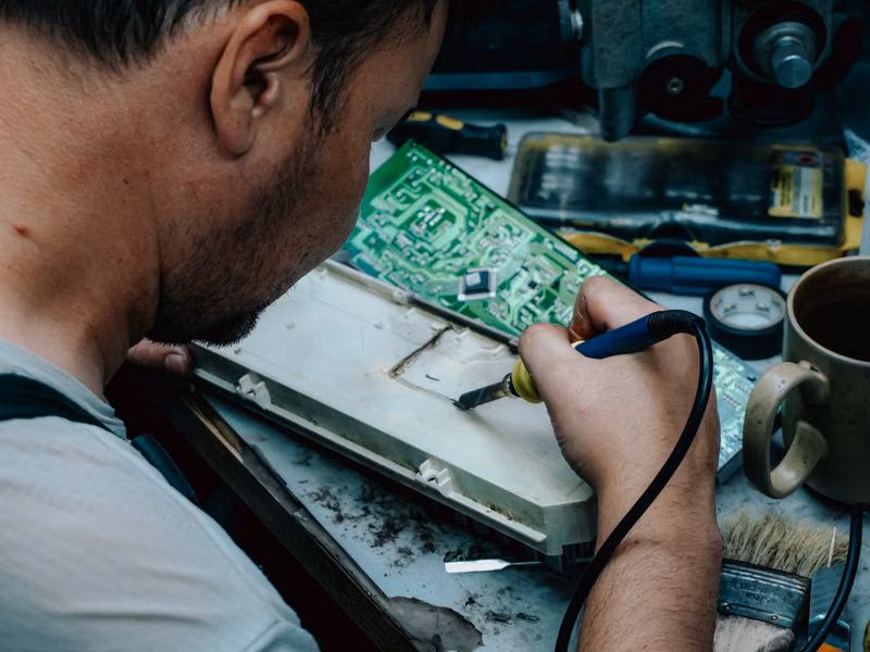 Close-up of a technician repairing an oven igniter