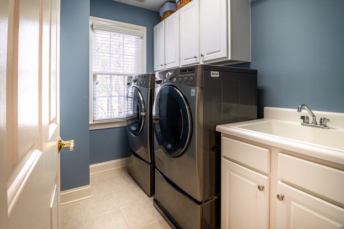 Appliance Matters technician repairing a washing machine in a Signal Hill laundry room