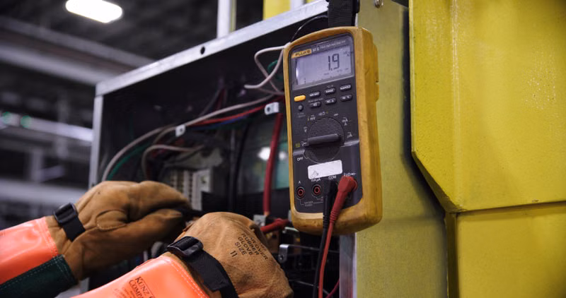 Technician performing a safety inspection on a gas range and oven