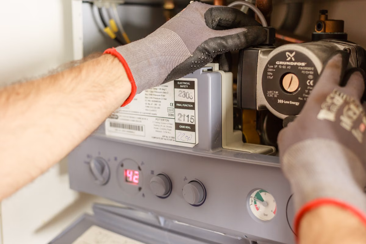 Appliance repair technician working on a stove in a Brentwood Calgary kitchen
